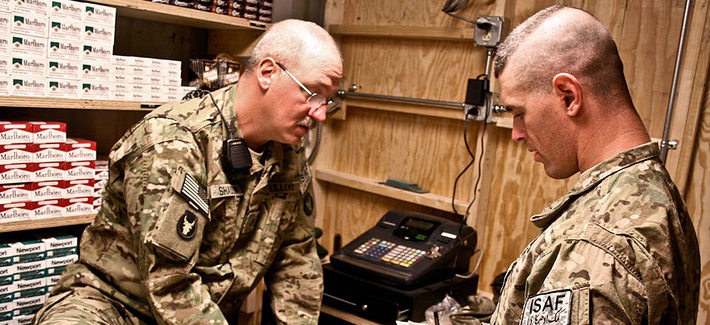 Two soldiers count sales at a new post exchange at Forward Operating Base Mehtar Two soldiers count sales at a new post exchange at Forward Operating Base Mehtar