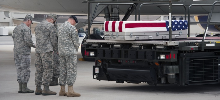 Troops say a prayer beside the transfer case containing the remains of Army Sgt. Michael Cable, 26, of Philpot, Ky., at Dover AFB in March. Troops say a prayer beside the transfer case containing the remains of Army Sgt. Michael Cable, 26, of Philpot, Ky., at Dover AFB in March.