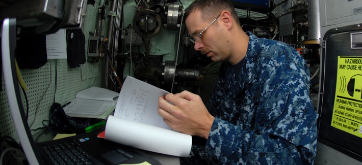 A corpsman examining medical records aboard the USS Montpelier A corpsman examining medical records aboard the USS Montpelier