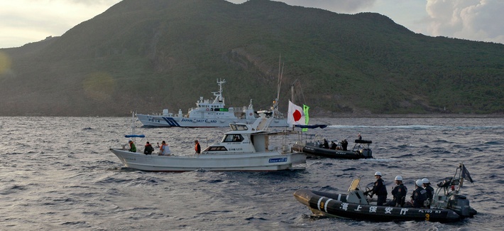 Japanese Coast Guard vessels sail alongside protestors near one of the Diaoyu/Senkaku Islands Japanese Coast Guard vessels sail alongside protestors near one of the Diaoyu/Senkaku Islands