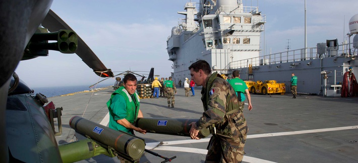 French troops load up munitions on a helicopter before an attack run in Libya. French troops load up munitions on a helicopter before an attack run in Libya.
