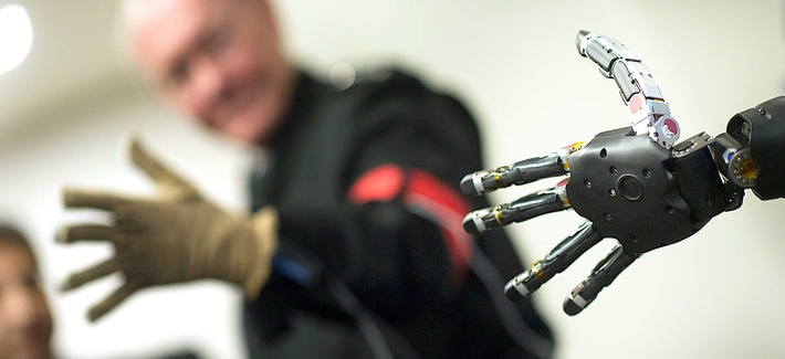 Joint Chiefs Chairman Gen. Martin Dempsey controlling a prosthetic arm during a visit to DARPA