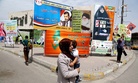 An Iraqi woman walks past a series of billboards advertising election candidates in Iraq