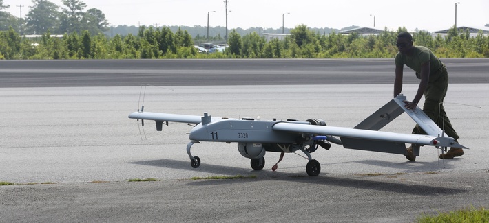 An avionics maintenance technician pushes an RQ7-B drone back to the taxiway after landing An avionics maintenance technician pushes an RQ7-B drone back to the taxiway after landing