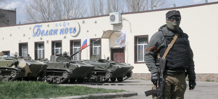 A masked pro-Russian gunman guards combat vehicles in Donetsk, Ukraine A masked pro-Russian gunman guards combat vehicles in Donetsk, Ukraine