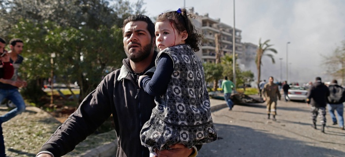 A Lebanese man carries an injured girl away from a car bombing in the suburbs of Beirut, Lebanon A Lebanese man carries an injured girl away from a car bombing in the suburbs of Beirut, Lebanon