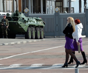 Two Ukrainian women walk past an armored personnel carrier in Kiev, Ukraine. Two Ukrainian women walk past an armored personnel carrier in Kiev, Ukraine.