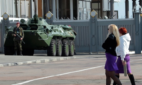 Two Ukrainian women walk past an armored personnel carrier in Kiev, Ukraine. Two Ukrainian women walk past an armored personnel carrier in Kiev, Ukraine.