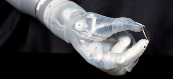 The DEKA Arm System, a product of DARPA's Revolutionizing Prosthetics program, is seen here holding a coin. The DEKA Arm System, a product of DARPA's Revolutionizing Prosthetics program, is seen here holding a coin.