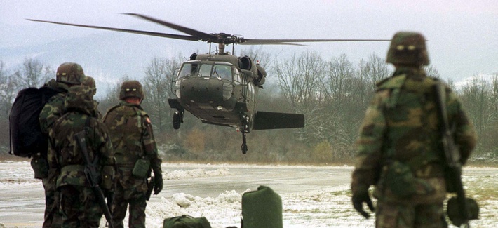 Two U.S. soldiers, members of the NATO mission to Bosnia, wait to board a helicopter, on February 14, 1999. Two U.S. soldiers, members of the NATO mission to Bosnia, wait to board a helicopter, on February 14, 1999.