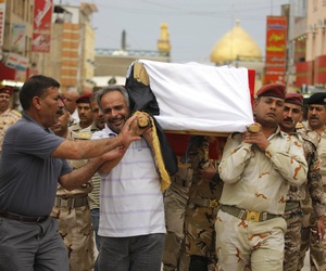 Mourners carry the flag draped coffin of an Iraqi Army colonel who was killed by Al Qaeda fighters, on April 14, 2014.