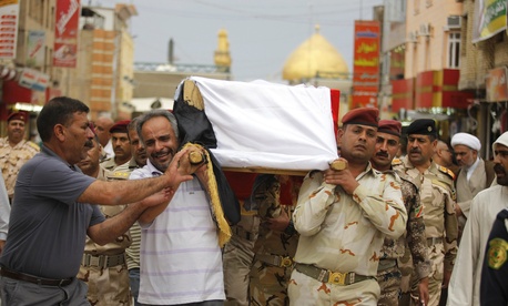 Mourners carry the flag draped coffin of an Iraqi Army colonel who was killed by Al Qaeda fighters, on April 14, 2014.
