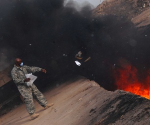 A sergeant tosses unusable uniform items into a burn pit at a base in Balad, Iraq, on March 10, 2008. A sergeant tosses unusable uniform items into a burn pit at a base in Balad, Iraq, on March 10, 2008.