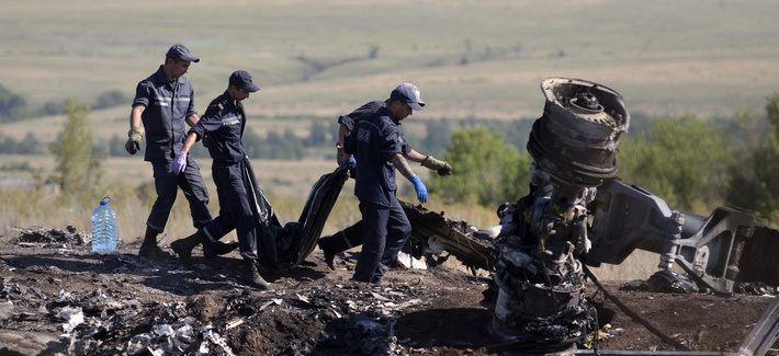 Ukrainian emergency workers on Monday carry a victim's body in a plastic bag at the crash site of Malaysia Airlines Flight 17. Ukrainian emergency workers on Monday carry a victim's body in a plastic bag at the crash site of Malaysia Airlines Flight 17.