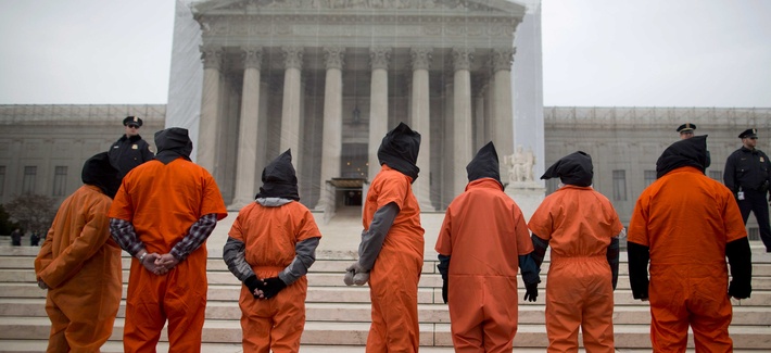 Demonstrators in front of the Supreme Court dress as detainees to protest against the military's detention facility at Guantanamo Bay, Cuba. Demonstrators in front of the Supreme Court dress as detainees to protest against the military's detention facility at Guantanamo Bay, Cuba.