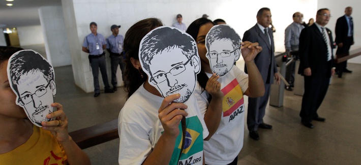 Activists hold up masks bearing the face of NSA leaker Edward Snowden at an internet conference in Brazil. Activists hold up masks bearing the face of NSA leaker Edward Snowden at an internet conference in Brazil.