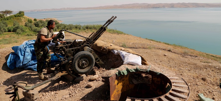 A Kurdish peshmerga fighter prepares his weapon at his combat position near the Mosul Dam at the town of Chamibarakat outside Mosul, Iraq, Aug 17, 2014. A Kurdish peshmerga fighter prepares his weapon at his combat position near the Mosul Dam at the town of Chamibarakat outside Mosul, Iraq, Aug 17, 2014.