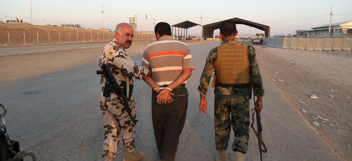 Kurdish Peshmerga fighters detain a man suspected as a militant for the ISIL. Kurdish Peshmerga fighters detain a man suspected as a militant for the ISIL.