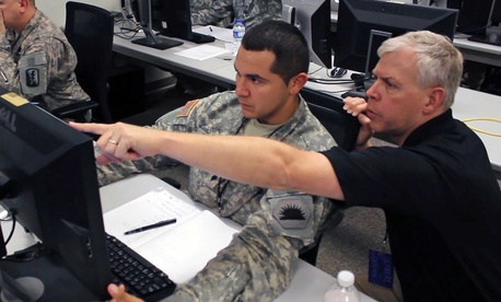 A network analyst with the California Army National Guard works with another analyst to defend against a virus attack during 2014 Cyber Shield exercise. A network analyst with the California Army National Guard works with another analyst to defend against a virus attack during 2014 Cyber Shield exercise.