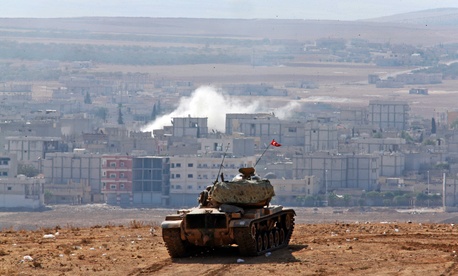 Turkish soldiers hold their position in a tank on the outskirts of Suruc, at the Turkey-Syria border, near the town of Kobani. Turkish soldiers hold their position in a tank on the outskirts of Suruc, at the Turkey-Syria border, near the town of Kobani.