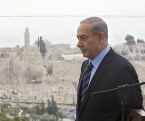 Israeli Prime Minister Benjamin Netanyahu walks past a window overlooking the Old City of Jerusalem, on Feb. 23, 2015.