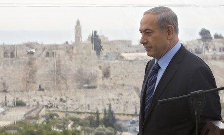 Israeli Prime Minister Benjamin Netanyahu walks past a window overlooking the Old City of Jerusalem, on Feb. 23, 2015.
