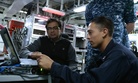 A member of Operation Trident Warrior shows sailors aboard the USS Peleliu how to use a Malicious Activity Security Tool. 