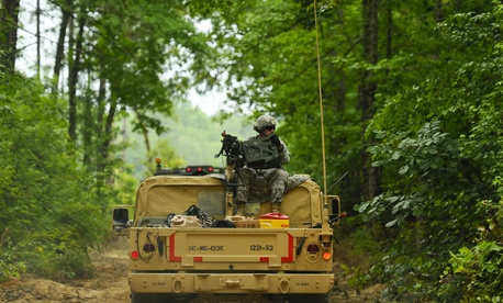 A soldier, assigned to 1221st Route Clearance Company, South Carolina Army National Guard, gunner on top a HMMVV scans for threats during route clearance operations at McCrady Training Center, Eastover, S.C., June 24, 2014. 