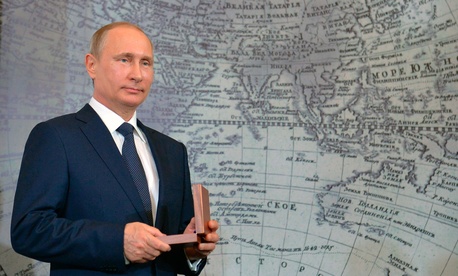 Russian President Vladimir Putin holds an award during a meeting of Russian Geographical Society in St Petersburg, Russia, Monday, April 27, 2015. Russian President Vladimir Putin holds an award during a meeting of Russian Geographical Society in St Petersburg, Russia, Monday, April 27, 2015.