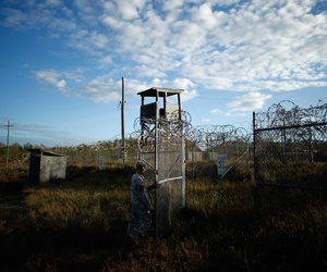 A U.S. soldier closes the gate at a now-abandoned detention facility at Naval Station Guantanamo Bay, Cuba, Nov. 13, 2013. 