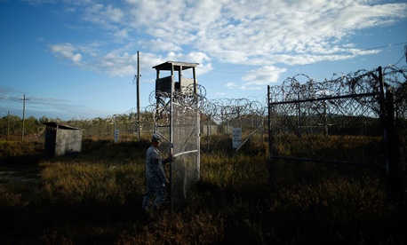 A U.S. soldier closes the gate at a now-abandoned detention facility at Naval Station Guantanamo Bay, Cuba, Nov. 13, 2013. 