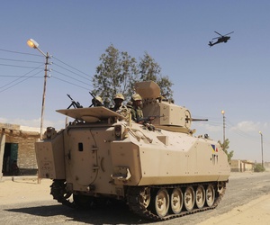 Egyptian Army soldiers patrol in an armored vehicle backed by a helicopter gunship during a sweep through villages in Sheikh Zuweyid, north Sinai, Egypt, on May 12, 2013. Egyptian Army soldiers patrol in an armored vehicle backed by a helicopter gunship during a sweep through villages in Sheikh Zuweyid, north Sinai, Egypt, on May 12, 2013.