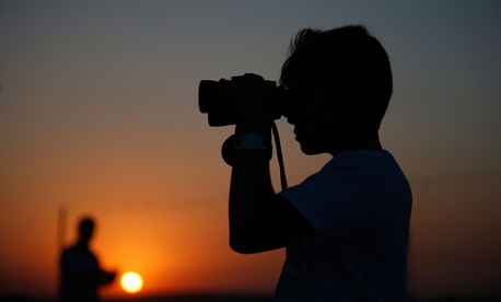 A youth uses binoculars to look at Turkish army tanks holding positions, near the border with Syria, in the outskirts of the village of Elbeyi, east of the town of Kilis, in southeastern Turkey, Thursday, July 23, 2015. A youth uses binoculars to look at Turkish army tanks holding positions, near the border with Syria, in the outskirts of the village of Elbeyi, east of the town of Kilis, in southeastern Turkey, Thursday, July 23, 2015.