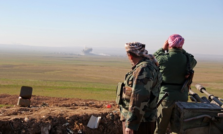 In this Tuesday, Jan. 20, 2015 image released by the Kurdistan Region Security Council (KRSC), Kurdish peshmerga forces watch smoke rise as fighters target Islamic State group positions in northern Iraq.