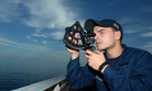 Quartermaster Seaman Pasquale V. Verrastro uses a sextant to find the range of a foreign vessel on the bridge wing of the guided-missile destroyer USS Ramage (DDG 61) in 2014.