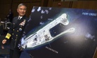 Adm. Harry B. Harris, Jr. of U.S. Navy Commander, U.S. Pacific Command walks past a photograph showing an island that China is building on the Fiery Cross Reef in the South China Sea, as the prepares to testify on Capitol Hill, Sept. 17, 2015.