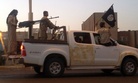 Islamic State militants parade in a commandeered Iraqi security forces vehicle in Mosul in 2014.