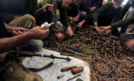 In this Wednesday, Nov. 14, 2012 file photo, Free Syrian Army fighters clean their weapons and check ammunition at their base on the outskirts of Aleppo, Syria.