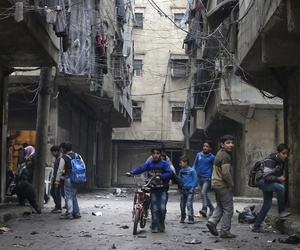 In this Thursday, Feb. 11, 2016 photo, school boys play in a street in Aleppo, Syria. In this Thursday, Feb. 11, 2016 photo, school boys play in a street in Aleppo, Syria.