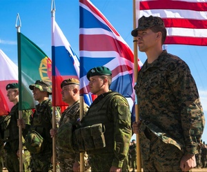 U.S. Marine Sgt. Steven Mashburn, a squad leader with Black Sea Rotational Force, right, holds the American flag during the opening ceremony for NATO's Exercise Saber Strike at the Pabrade Training Area, Lithuania, June 8, 2015.