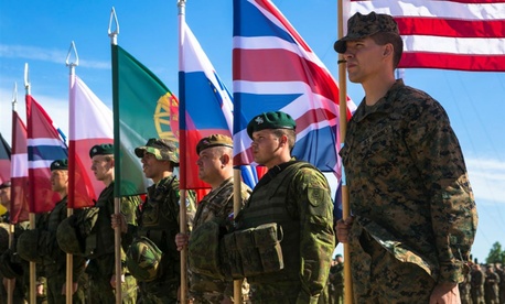 U.S. Marine Sgt. Steven Mashburn, a squad leader with Black Sea Rotational Force, right, holds the American flag during the opening ceremony for NATO's Exercise Saber Strike at the Pabrade Training Area, Lithuania, June 8, 2015.