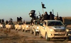 Members of the Islamic State hold up their weapons and wave its flags in a convoy on a road in Raqqa, Syria in this photo, released online in the summer of 2014 on a militant social media account. Members of the Islamic State hold up their weapons and wave its flags in a convoy on a road in Raqqa, Syria in this photo, released online in the summer of 2014 on a militant social media account.