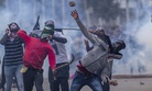 Masked Kashmiri protesters throw rocks at government forces during a protest outside Eidgha, a prayer ground, in Srinagar, Indian controlled Kashmir, Saturday, Sept. 2, 2017.