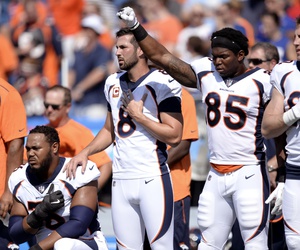 Denver Broncos tight end Virgil Green (85) gestures as teammate Max Garcia, left, takes a knee during the paying of the national anthem prior to an NFL football game against the Buffalo Bills, Sunday, Sept. 24, 2017, in Orchard Park, N.Y. Denver Broncos tight end Virgil Green (85) gestures as teammate Max Garcia, left, takes a knee during the paying of the national anthem prior to an NFL football game against the Buffalo Bills, Sunday, Sept. 24, 2017, in Orchard Park, N.Y.