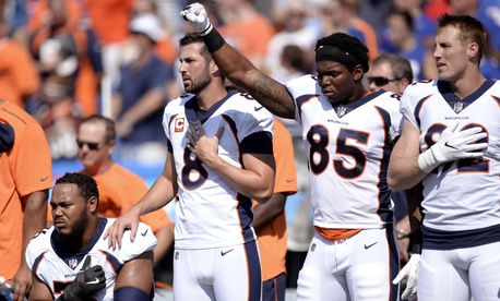 Denver Broncos tight end Virgil Green (85) gestures as teammate Max Garcia, left, takes a knee during the paying of the national anthem prior to an NFL football game against the Buffalo Bills, Sunday, Sept. 24, 2017, in Orchard Park, N.Y. Denver Broncos tight end Virgil Green (85) gestures as teammate Max Garcia, left, takes a knee during the paying of the national anthem prior to an NFL football game against the Buffalo Bills, Sunday, Sept. 24, 2017, in Orchard Park, N.Y.