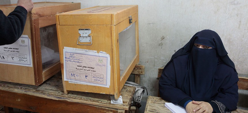 A representative for an Egyptian candidate watches a ballot box during a second round election held in December 2011