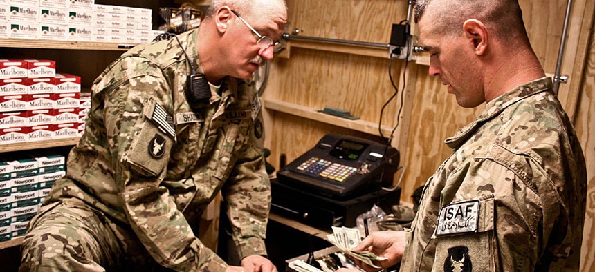 Two soldiers count sales at a new post exchange at Forward Operating Base Mehtar