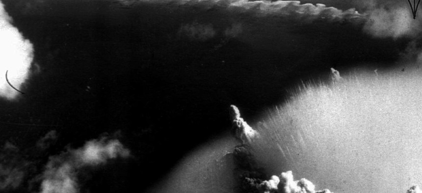The mushroom cloud of an atomic bomb test at Bikini atoll swamps ships, in 1946.