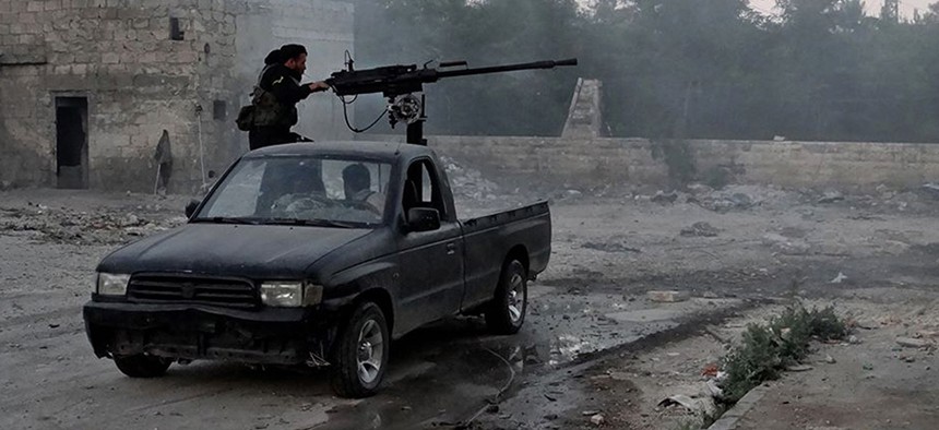 Syrian rebels firing heavy machine gun at troops loyal to Syria's current president Bashar Assad