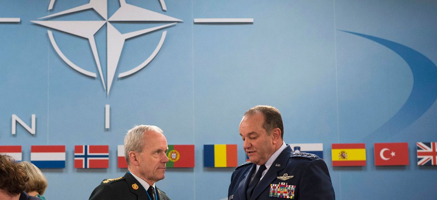 At right, NATO’s Supreme Allied Commander for Europe, Gen. Philip Breedlove, speaks with Chairman of the NATO Military Committee, General Knud Bartels, during a meeting of NATO defense ministers in June 2013.